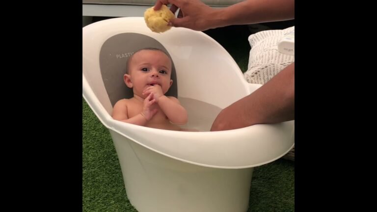 bebe feliz en banera con aro seguro