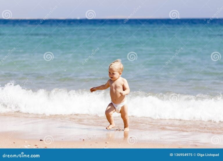 Cómo elegir los mejores pañales para agua para tu bebé 19 bebe jugando en la playa con panales