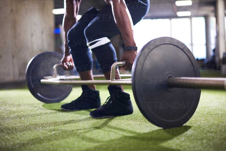 hombre levantando barra en gimnasio