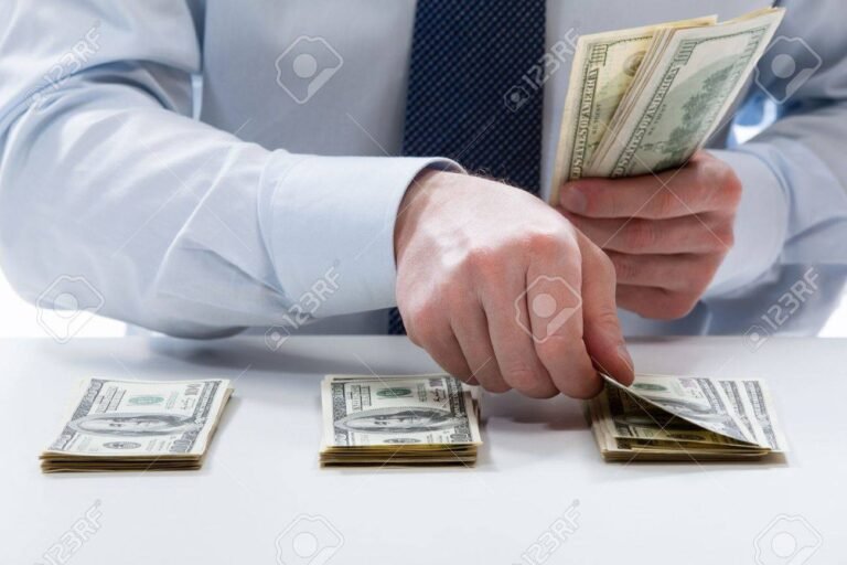 manos contando billetes en una mesa