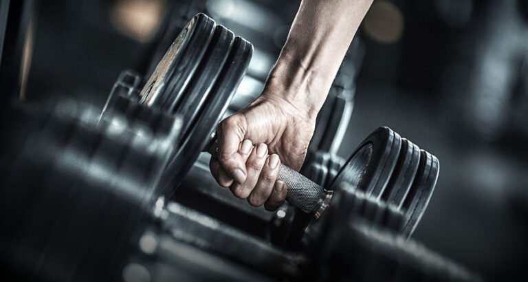 En qué se diferencia el poder de la fuerza en la vida cotidiana 2 manos levantando pesas en un gimnasio