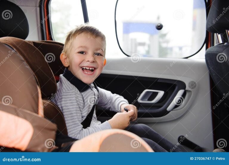 nino feliz en un asiento de auto