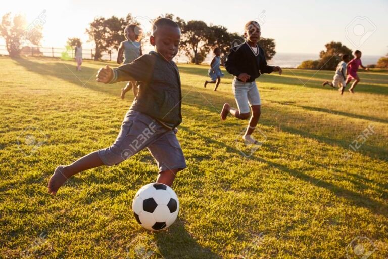 ninos jugando futbol en un campo