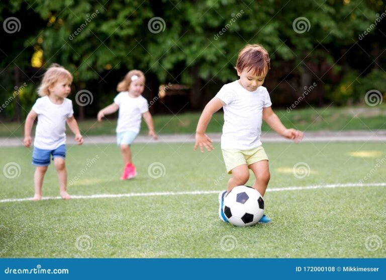 ninos jugando futbol en un campo verde