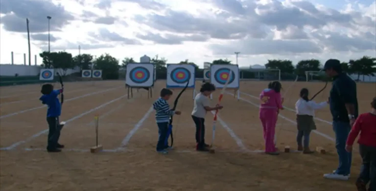 Qué beneficios trae el uso del arco y flecha para niños 25 ninos practicando tiro con arco al aire libre
